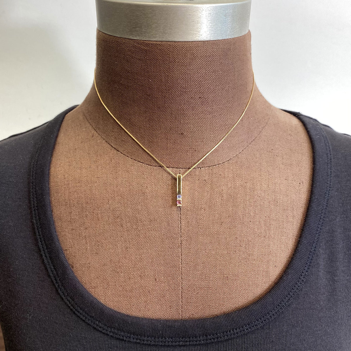 modern pendant in yellow gold with channel set gemstones